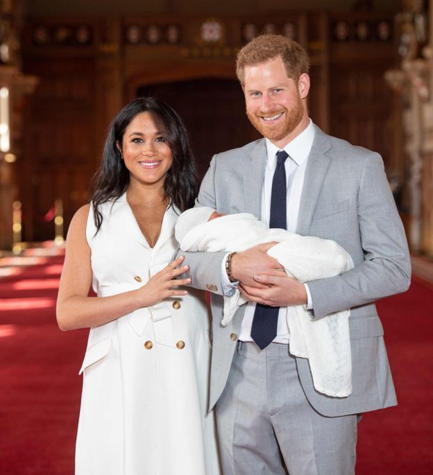 Harry and Meghan Markle pose with their new born child